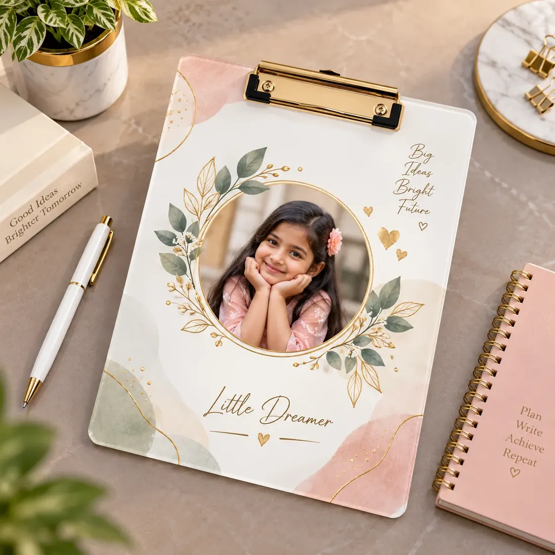 Acrylic writing pad with a gold clip, printed with a child’s photograph in a floral wreath and the name “Little Dreamer” — Siri Print World, Palakollu